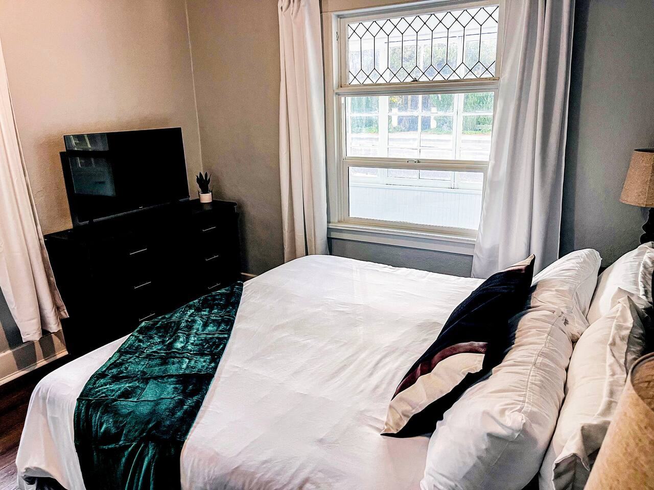 King bedroom with dresser and TV