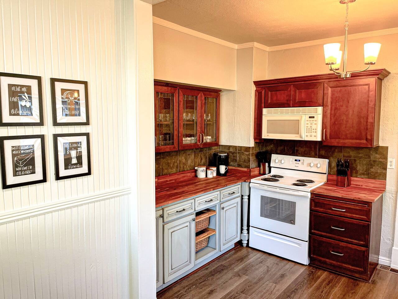 Kitchen with cherry cabinets, white range and microwave