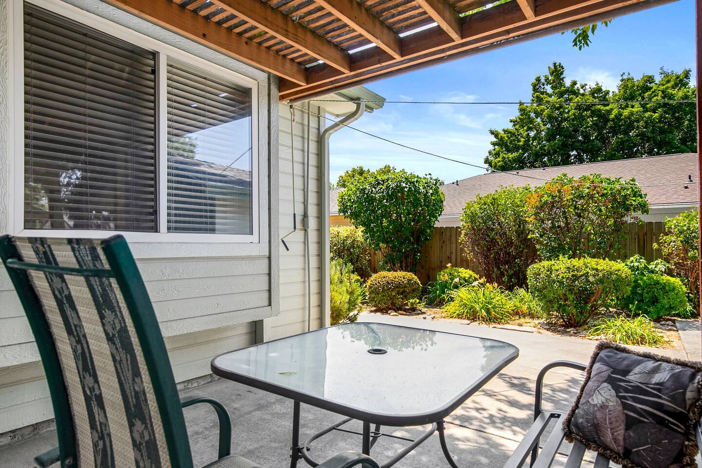 Covered patio seating looking onto the landscaped yard