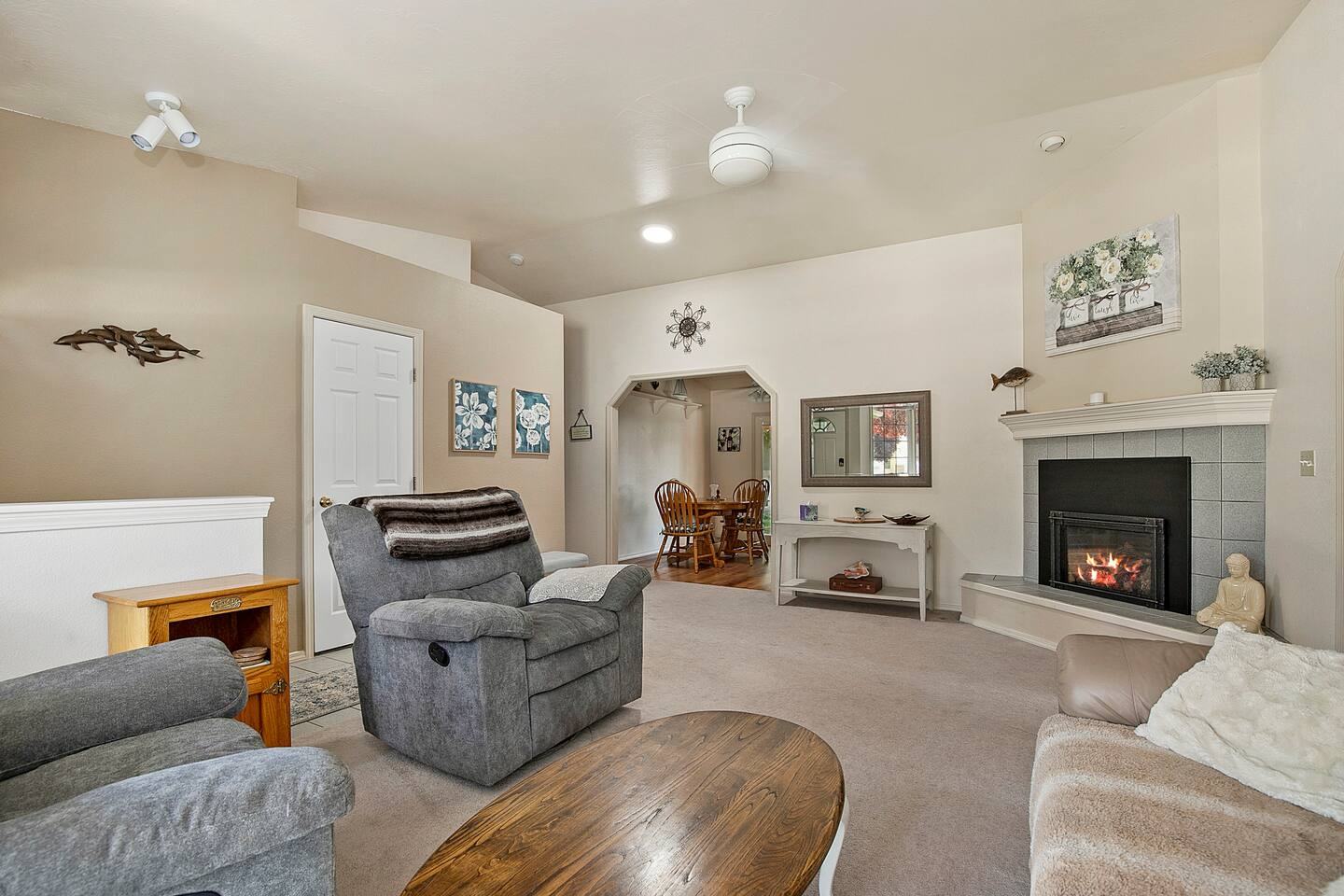 Family room with a fireplace, recliners and a ceiling fan