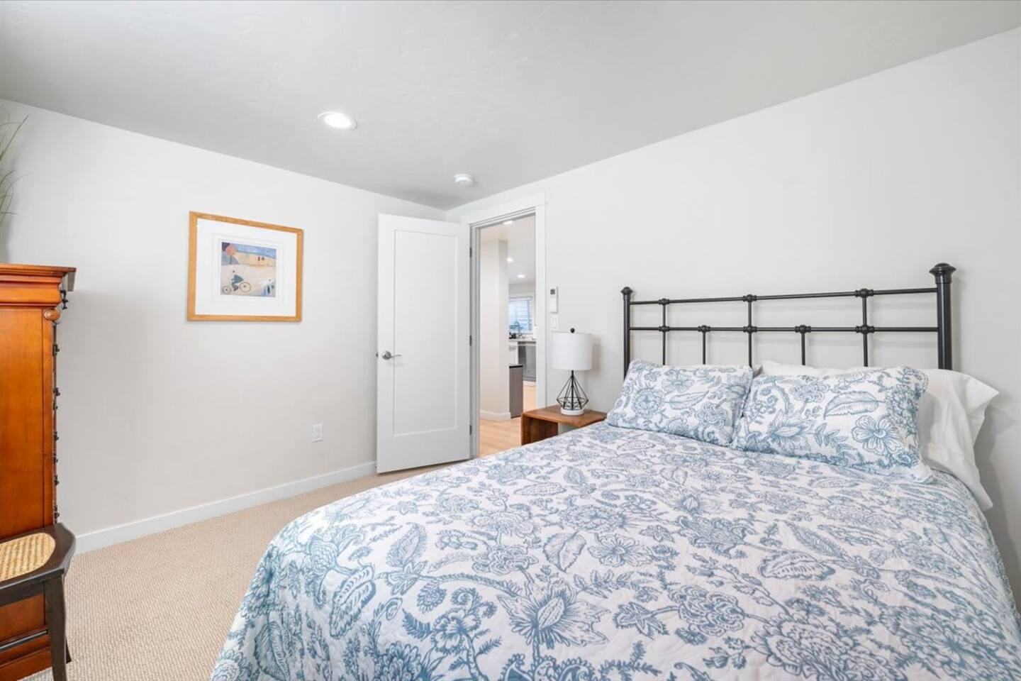 Bedroom with an iron bed frame and blue floral bedding