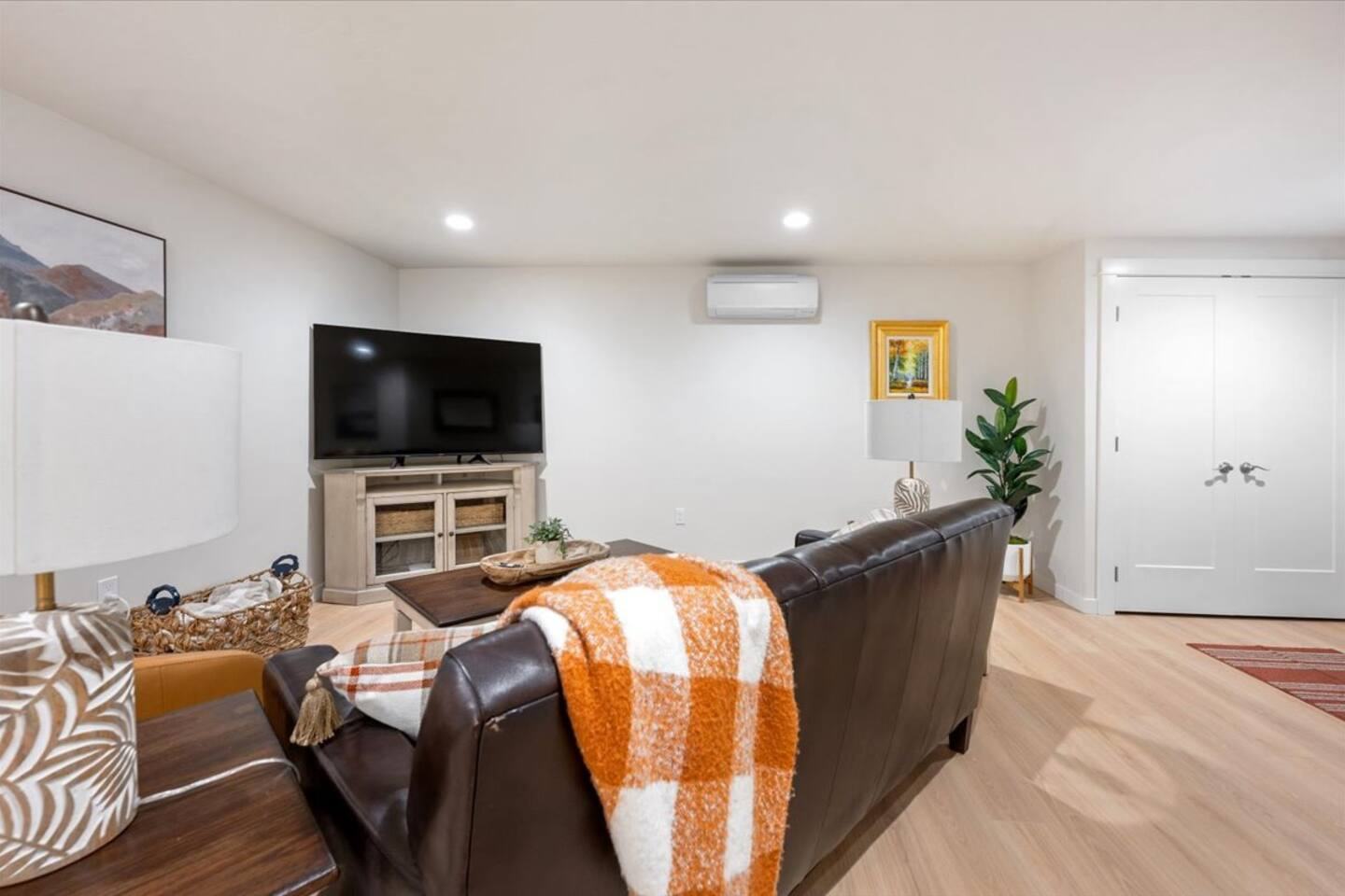 Living room with leather sofa, Smart TV and mini split