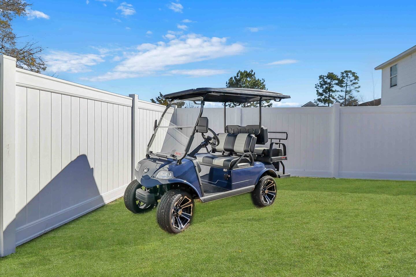 Golf cart parked in the fenced backyard