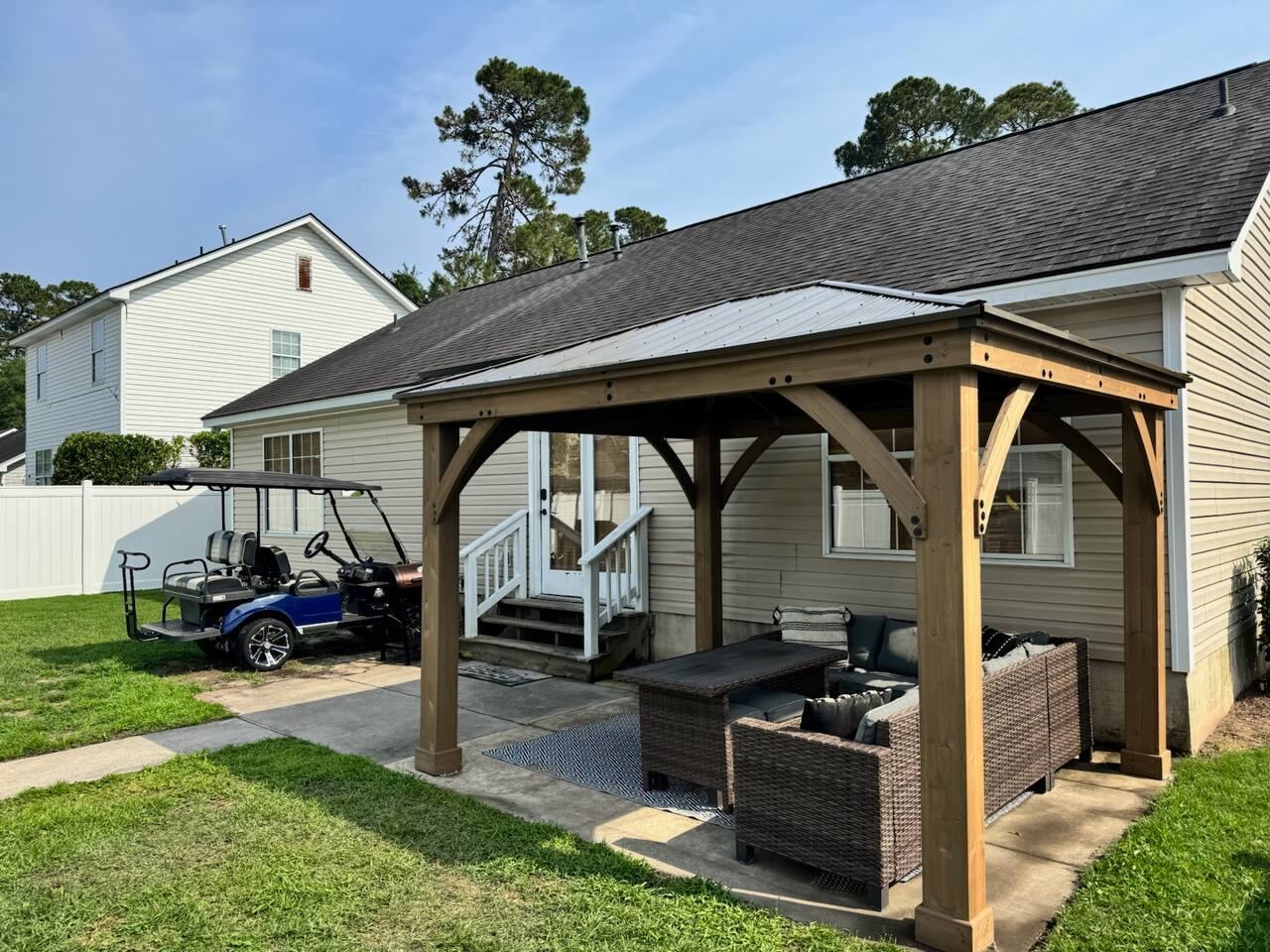 Covered gazebo with outdoor seating in the fenced backyard
