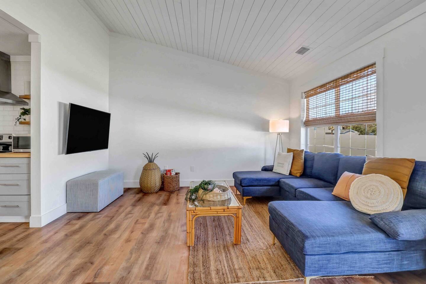 Living room with blue sectional sofa and wall-mounted TV