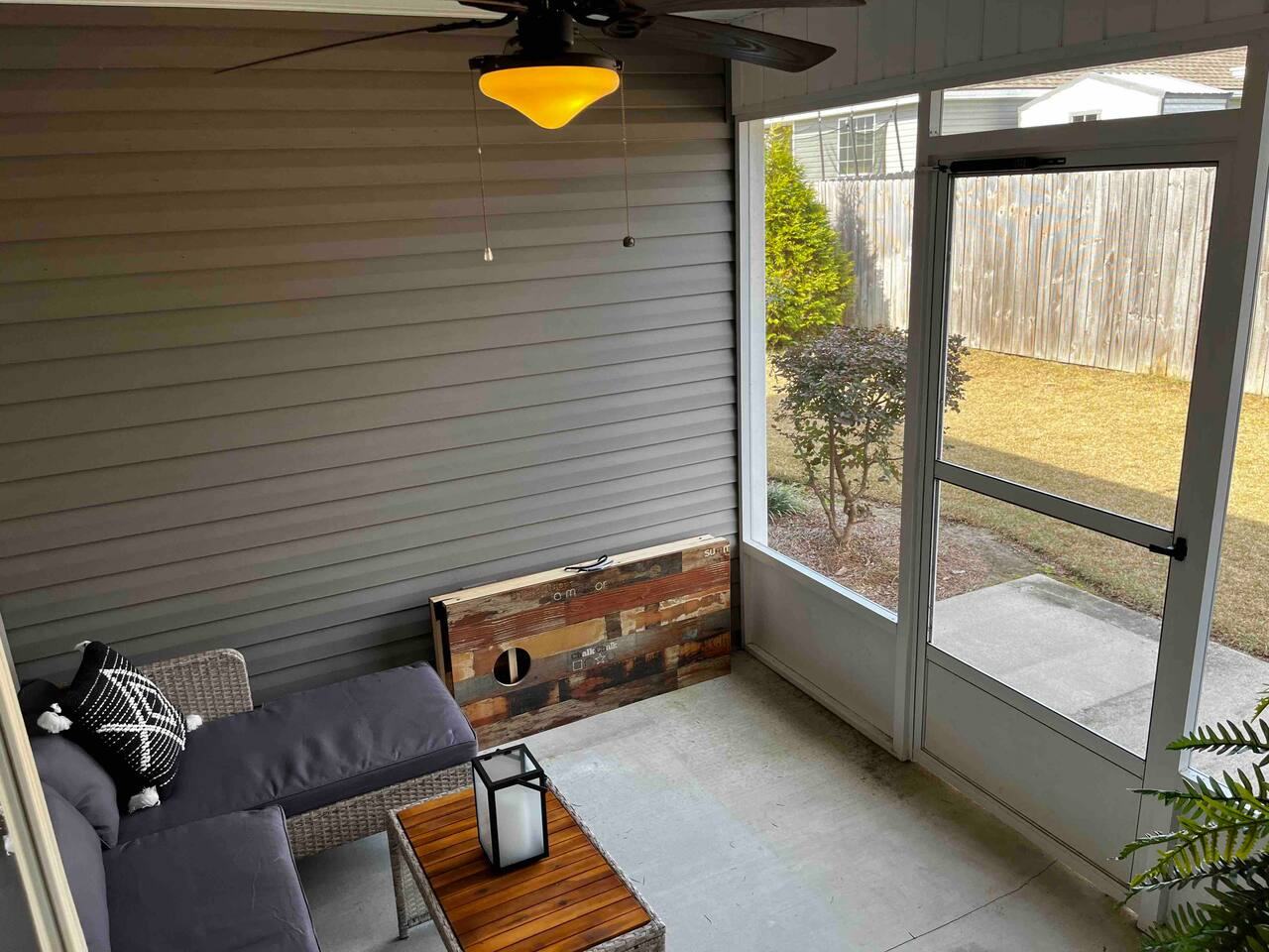 Screened porch with ceiling fan and view of the backyard