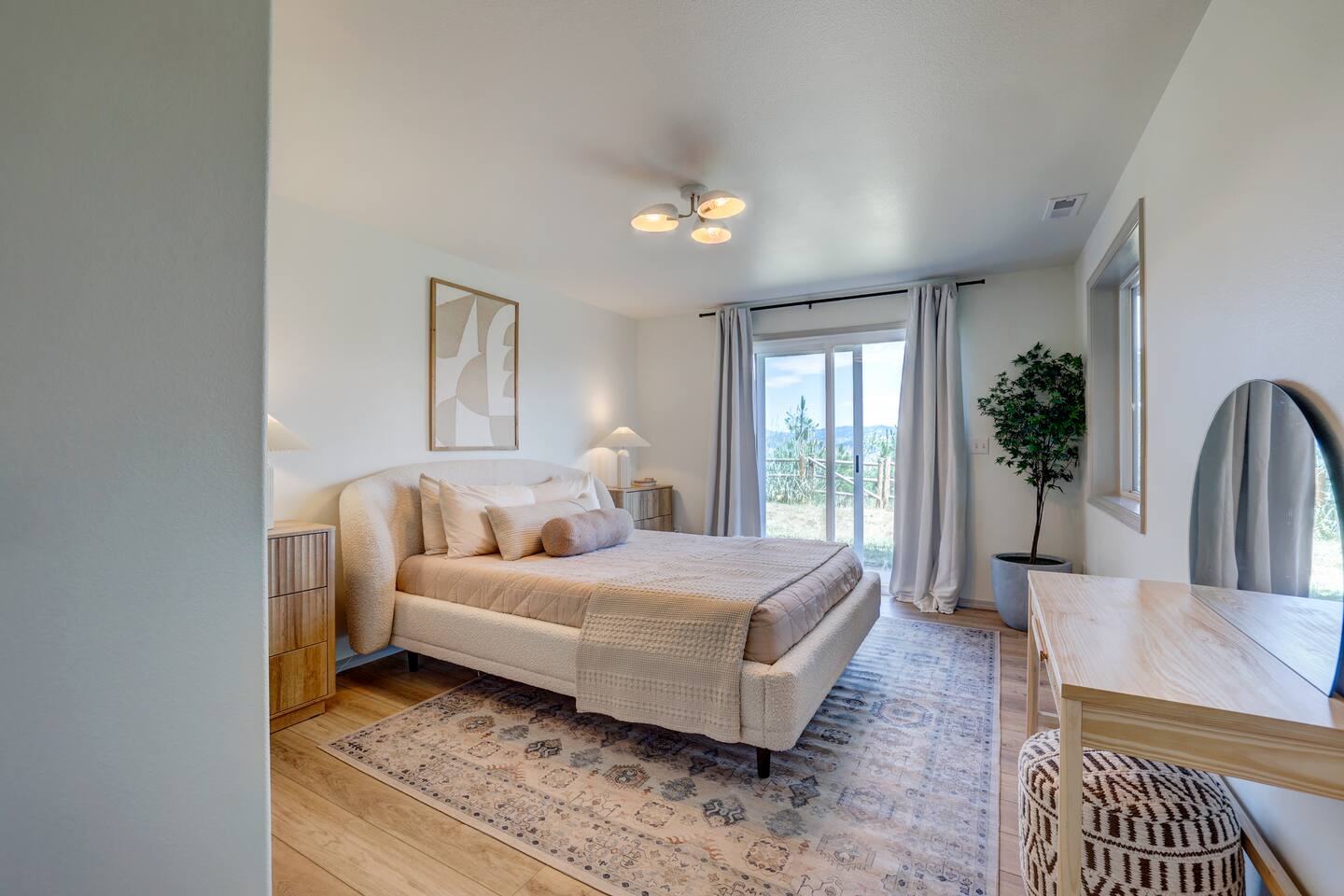 First queen bedroom with upholstered bed and patio door