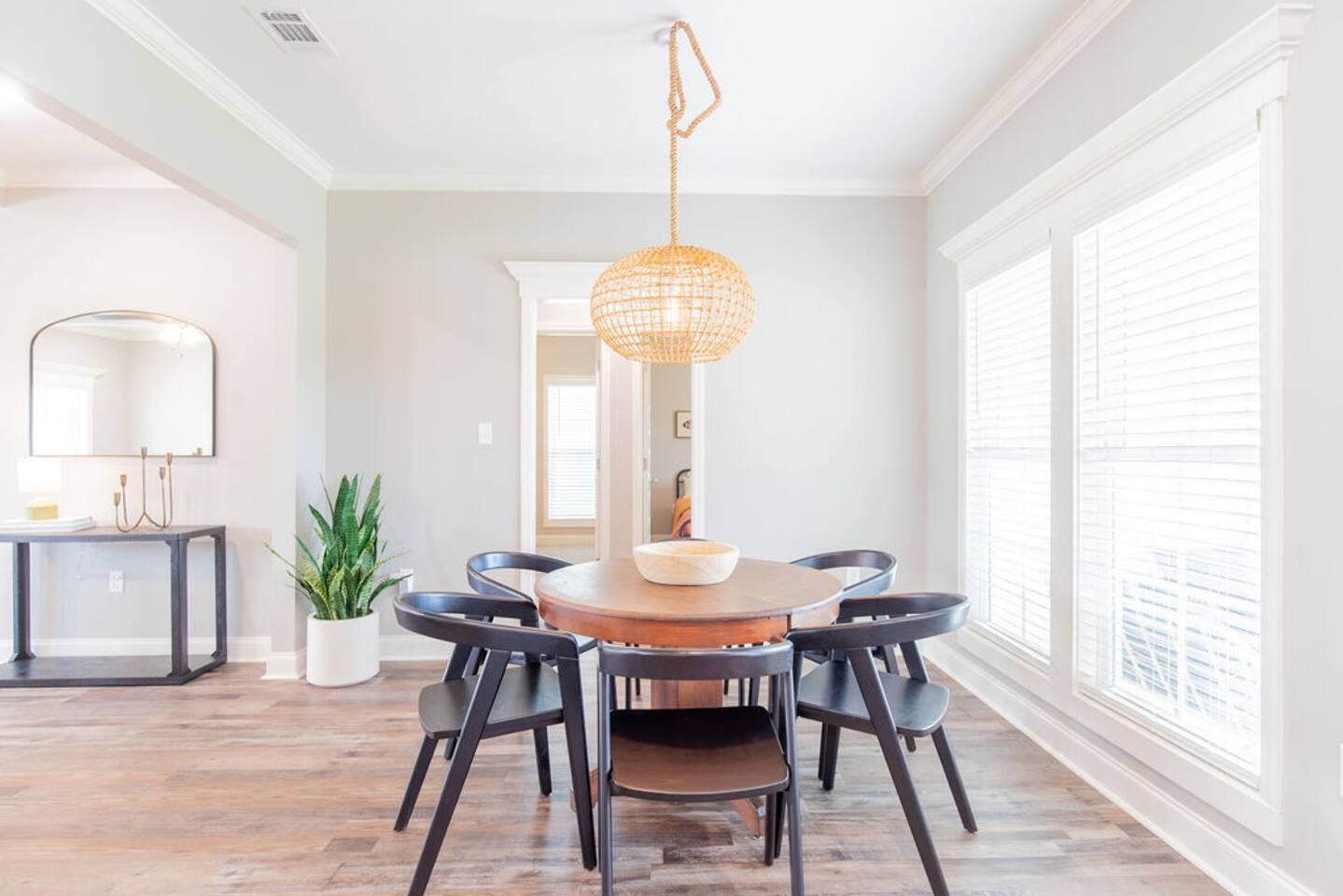 Dining nook with round table, six chairs and woven pendant light