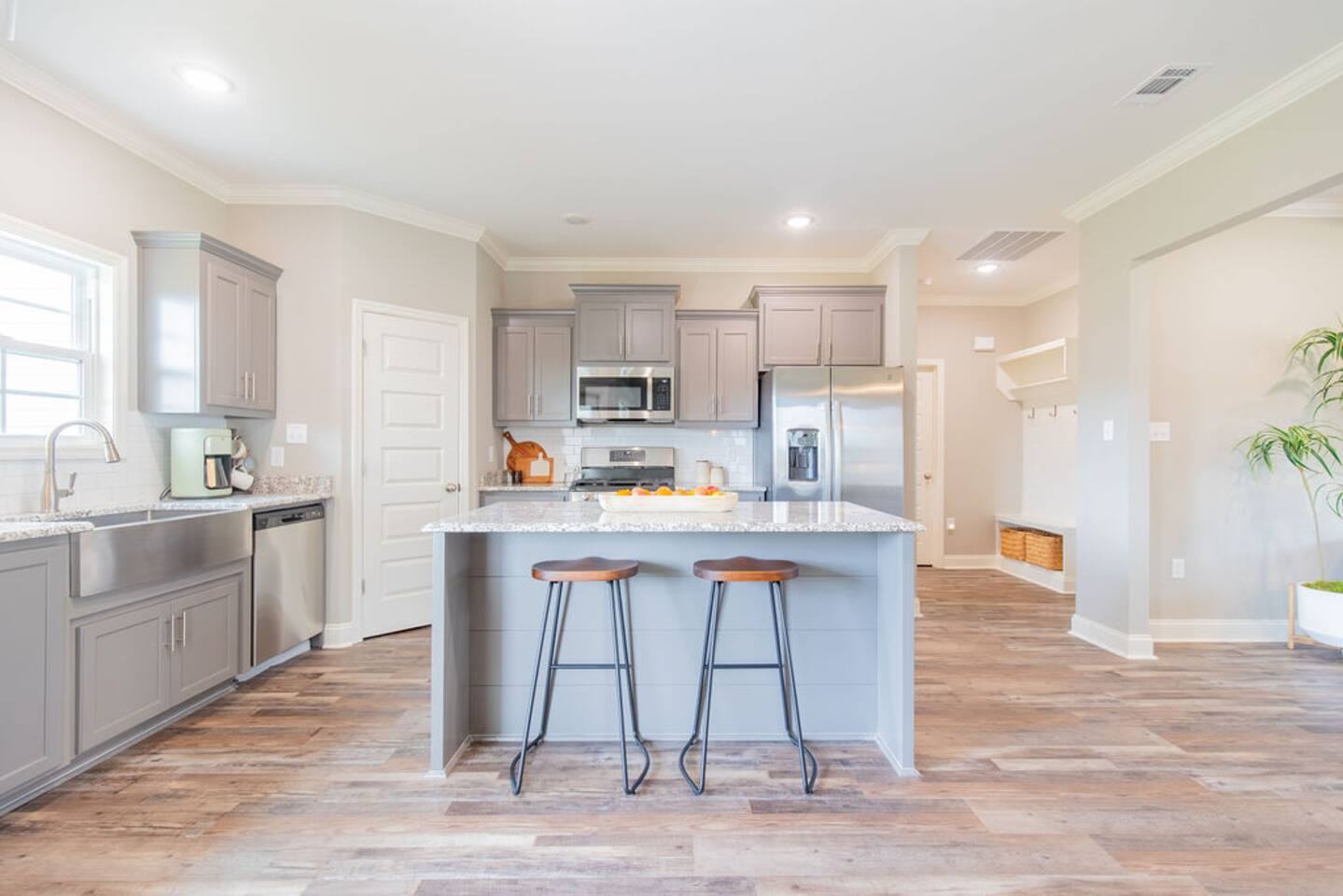 Kitchen with gray cabinets, center island and two bar stools
