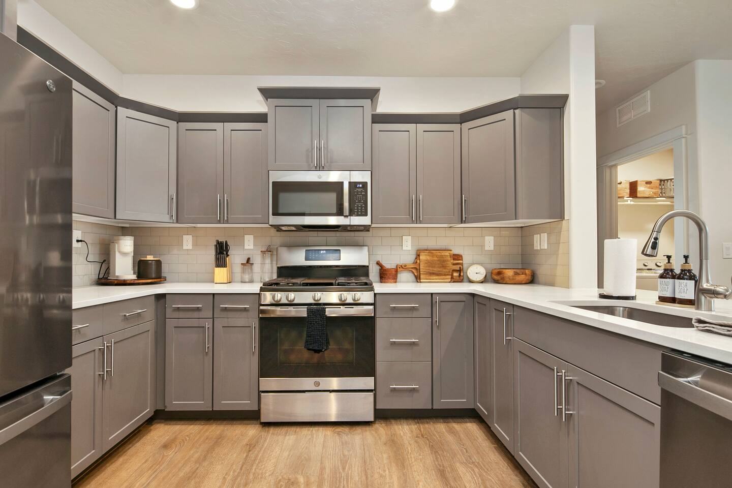 Kitchen with gray cabinets, gas range and stainless appliances