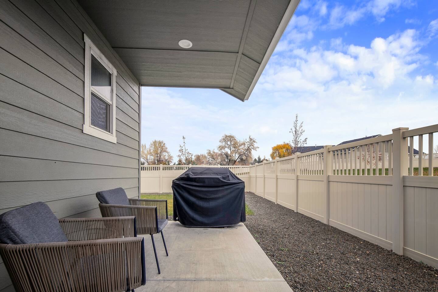 Covered back patio with seating and barbecue grill