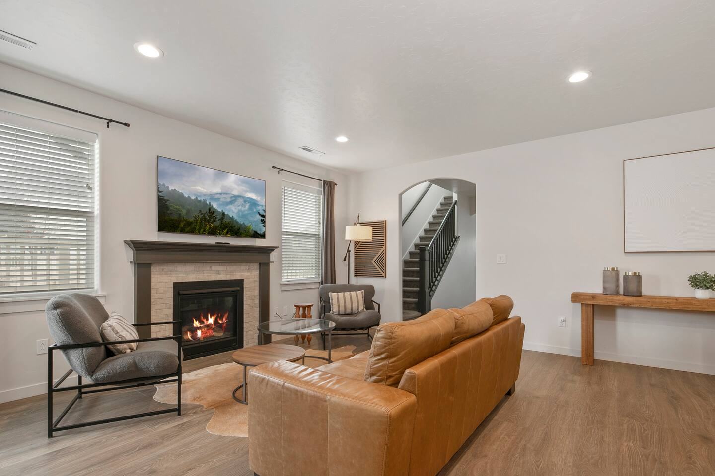 Open great room with fireplace, armchairs and stairs to the upstairs lounge