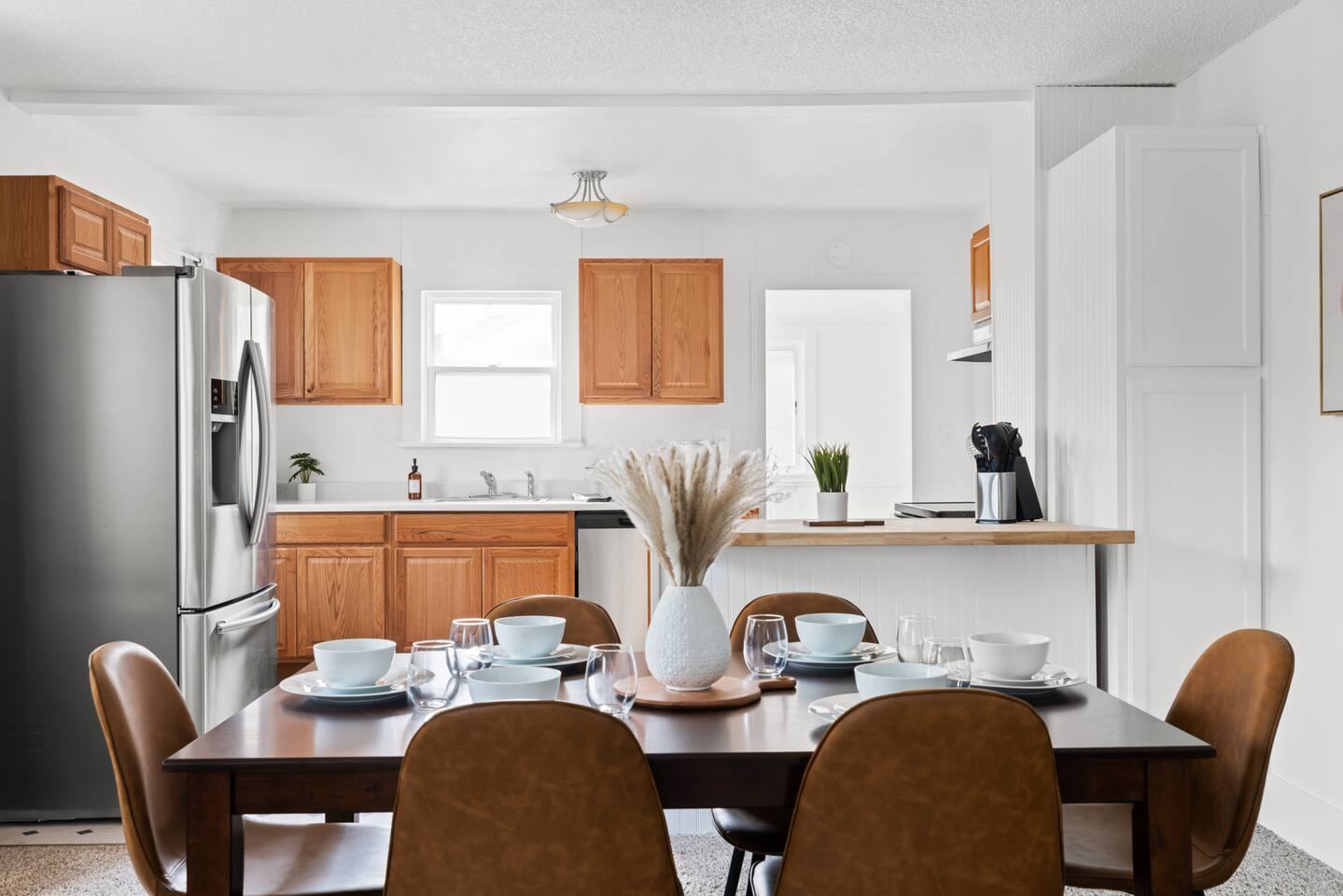 Dining table set for six in front of the kitchen