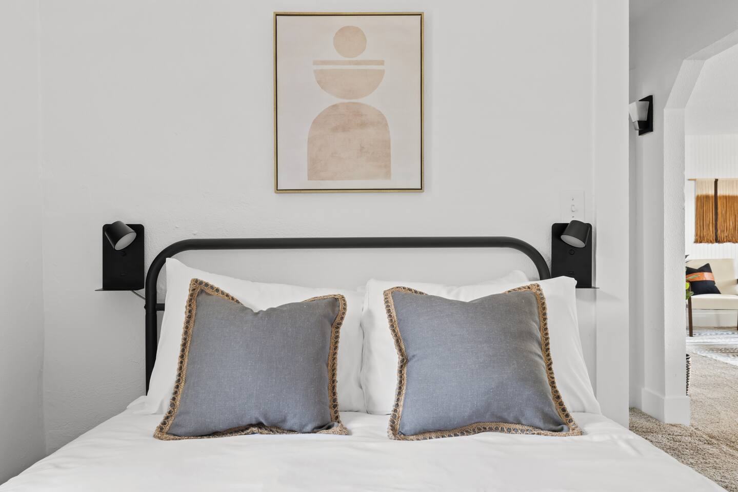 Bedroom with black metal bed frame and gray pillows