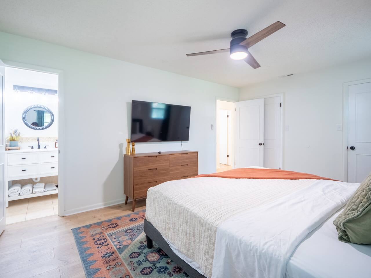 Primary bedroom with king bed, TV and ensuite bath