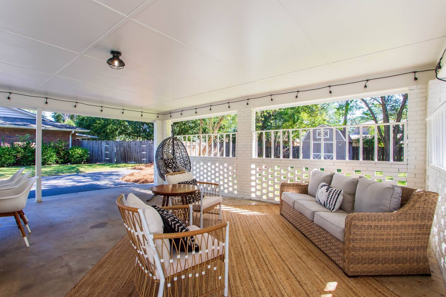 Screened porch lounge with wicker sofa and armchairs
