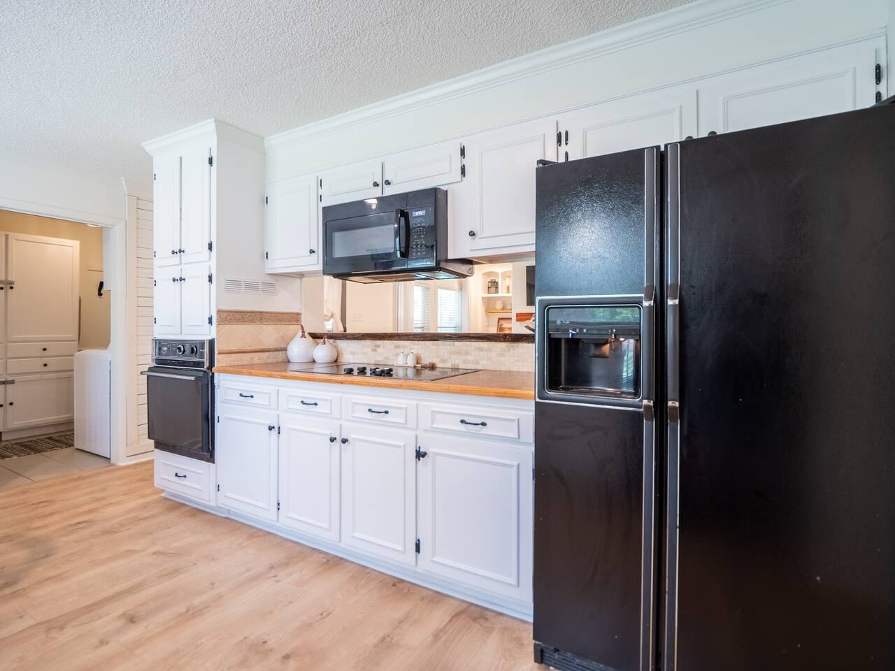 Kitchen with black refrigerator, microwave and range