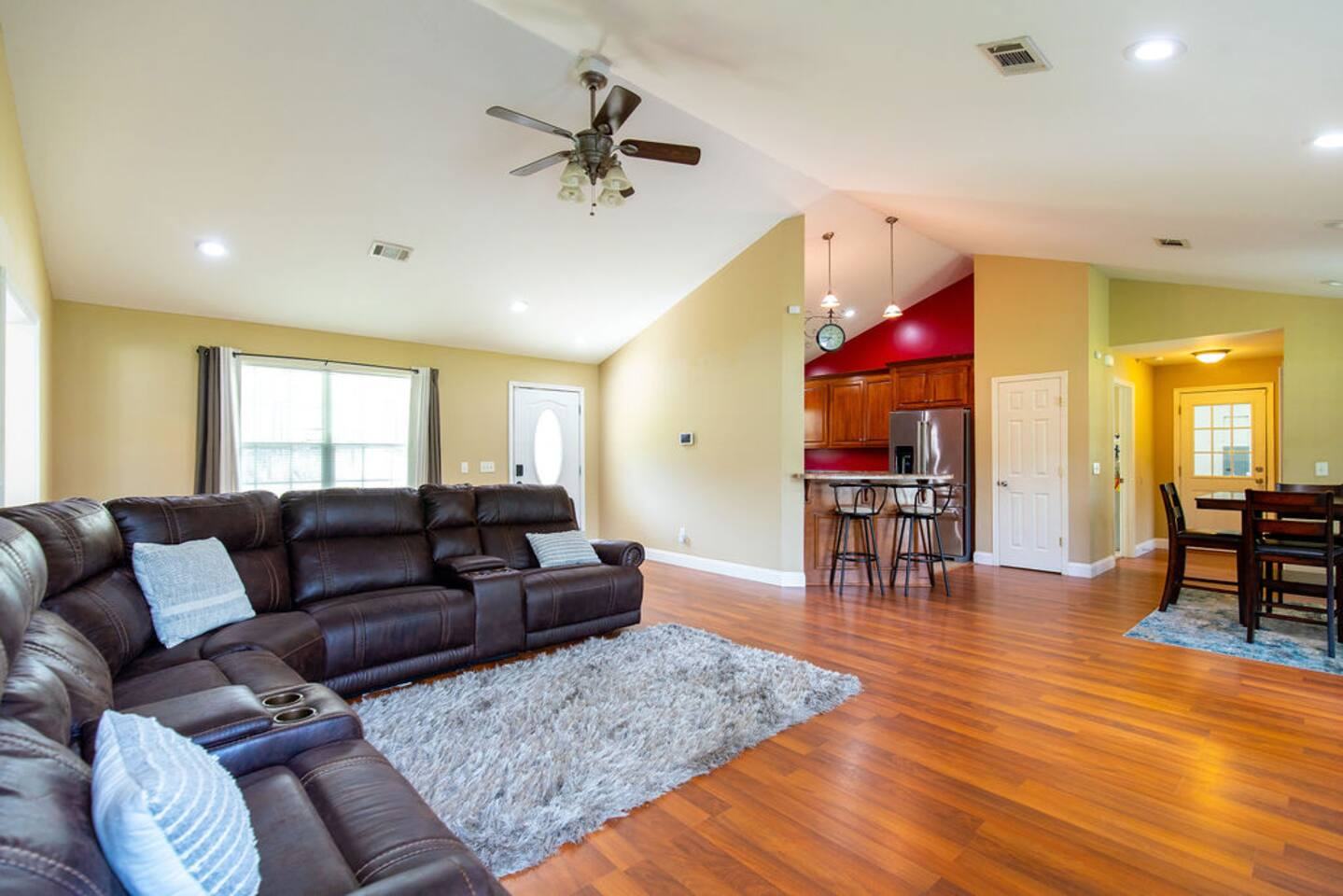 Great room with leather sectional, vaulted ceiling and view into the kitchen