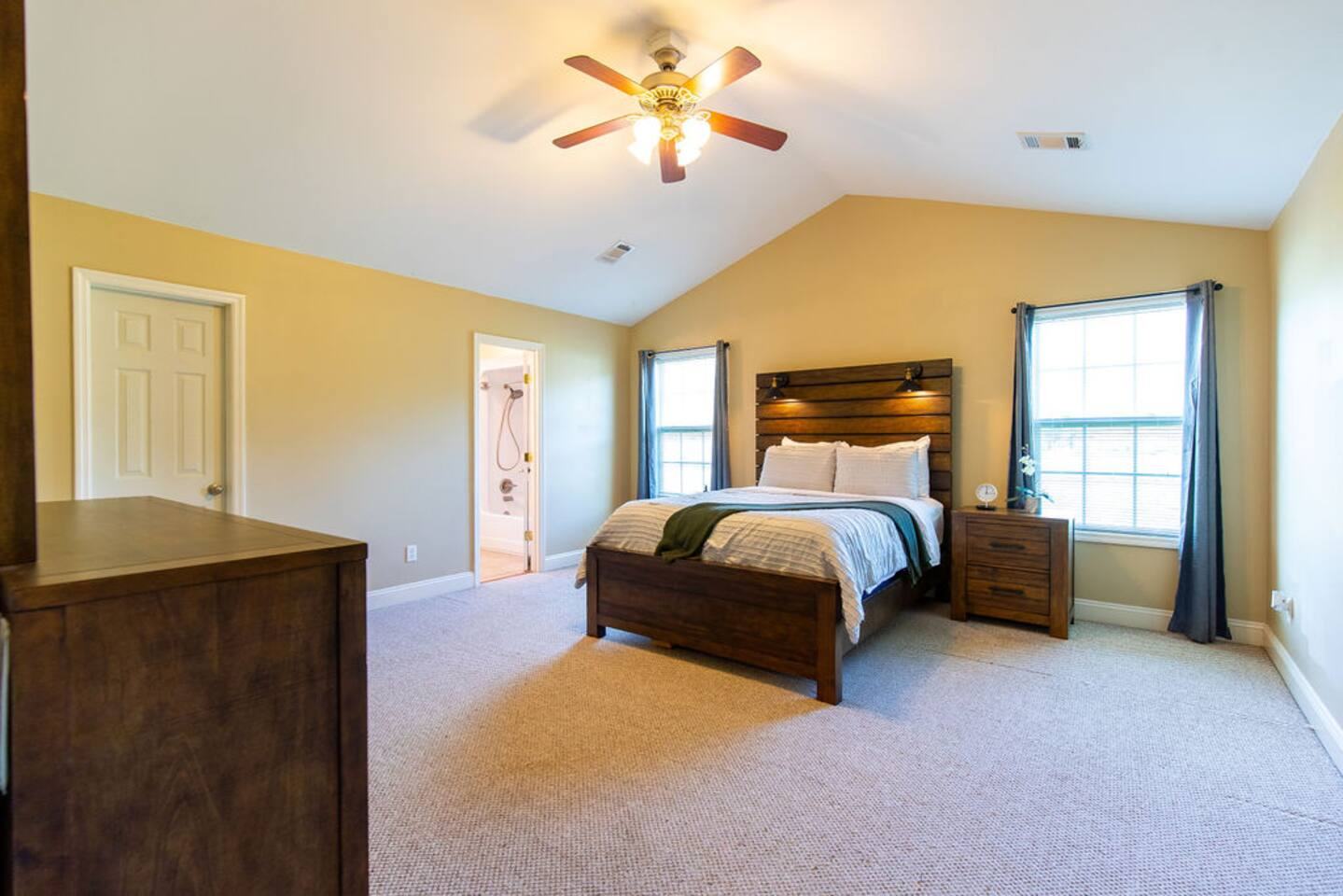 Primary bedroom with queen bed under a vaulted ceiling