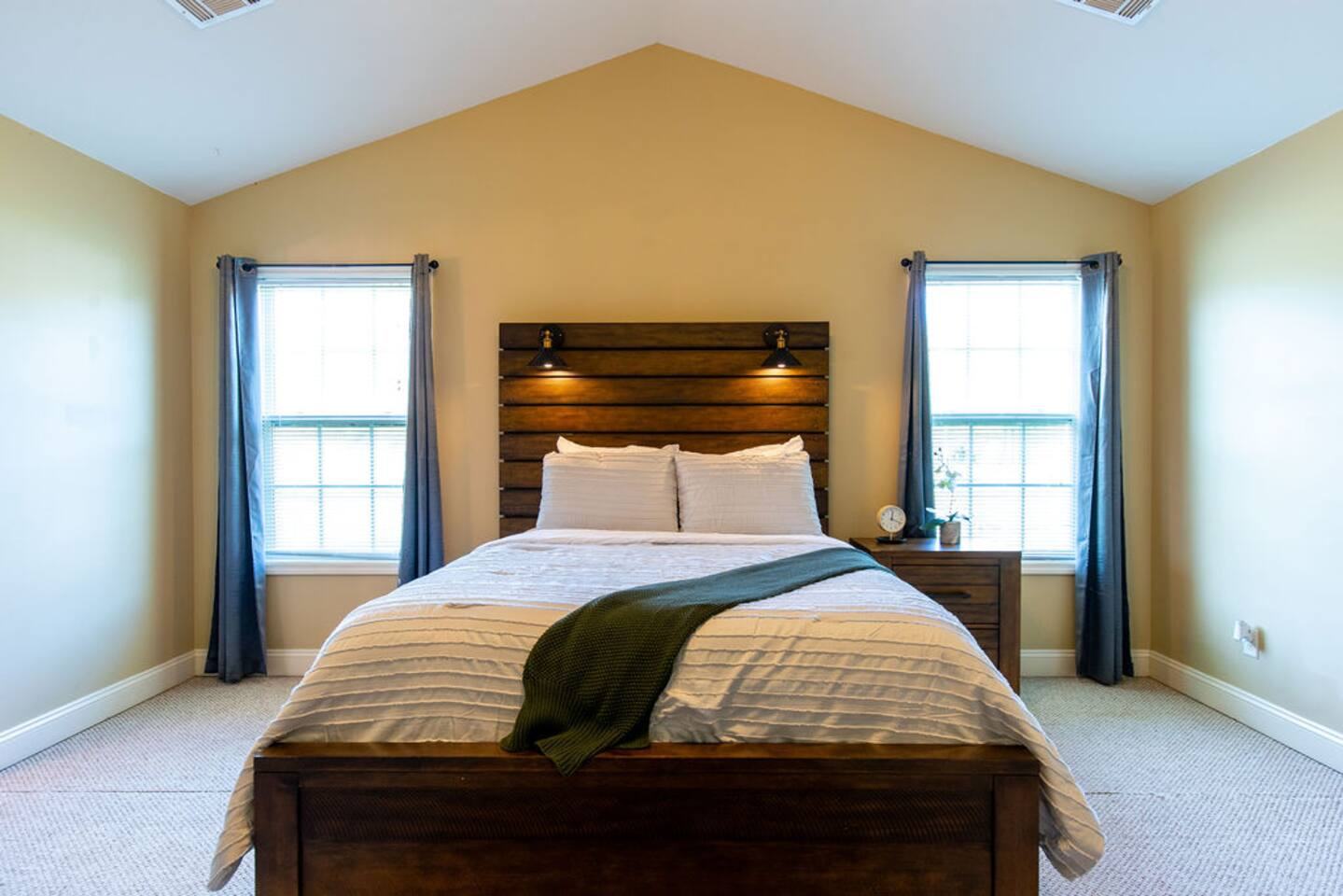 Primary bedroom with queen bed and wood headboard