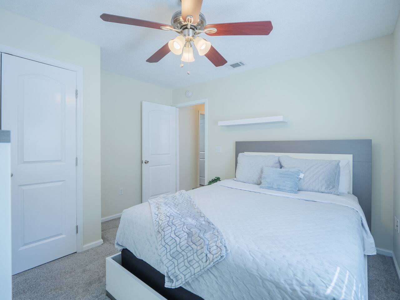 Second bedroom with white platform bed and blue accent pillows