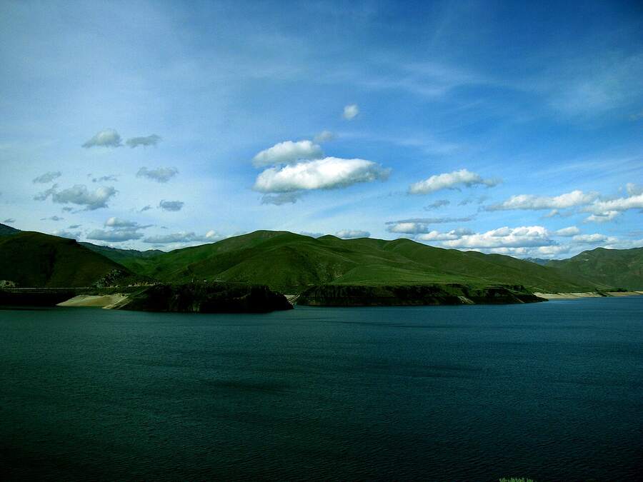 Lucky Peak Lake with green hills under a blue sky