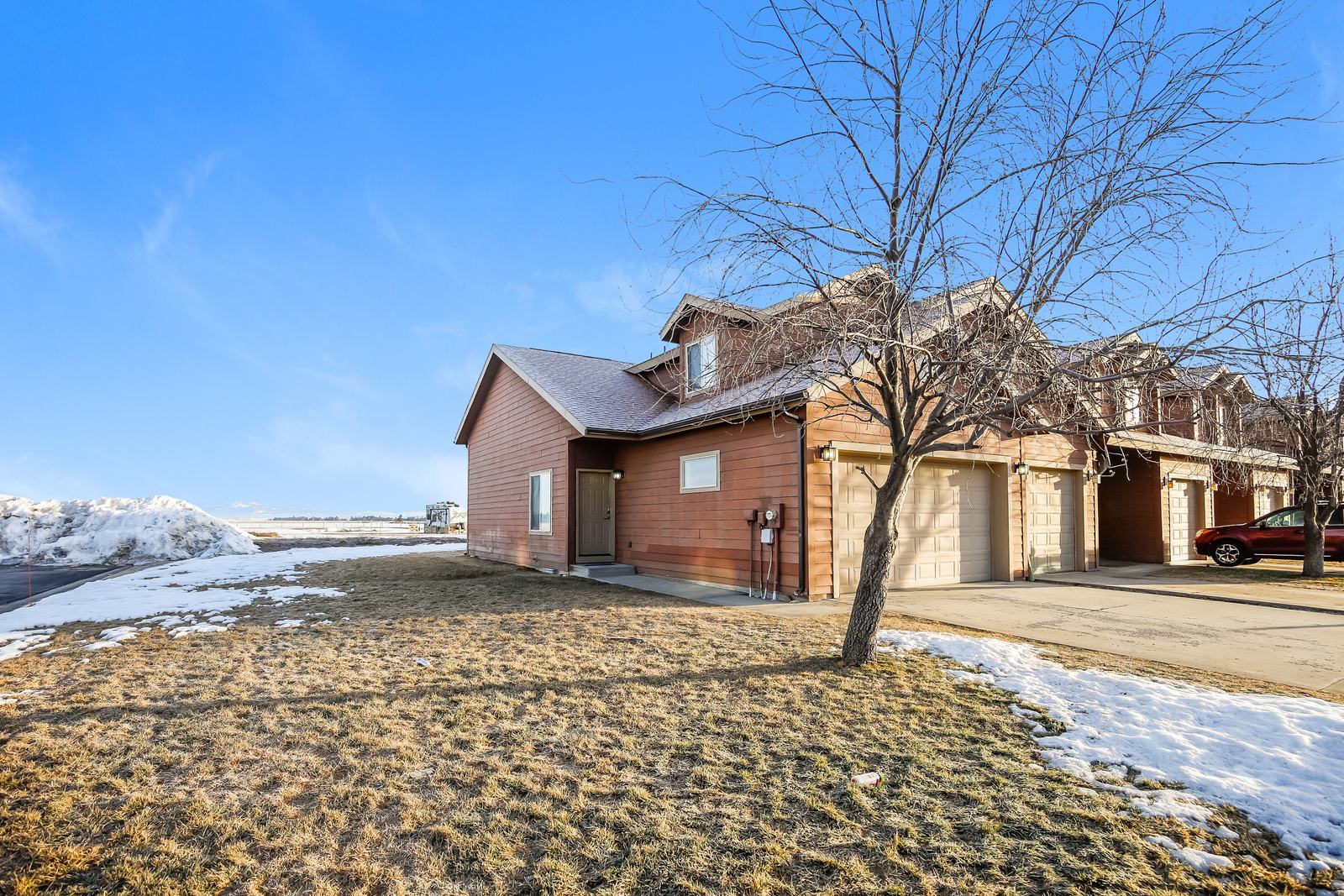 End-unit home with attached garage, large side yard, and open views
