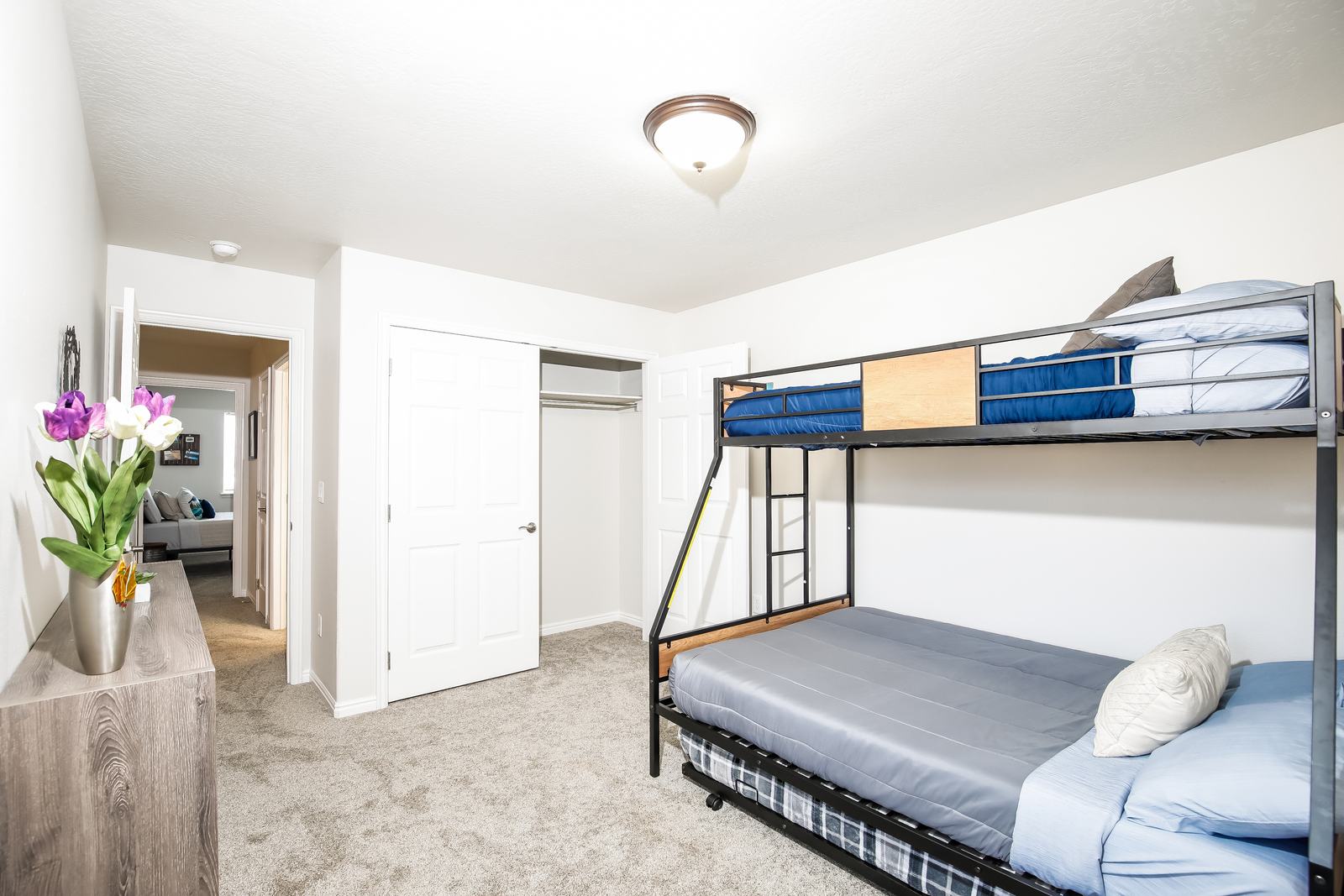 Bright bunk room with twin-over-full, trundle, and open closet