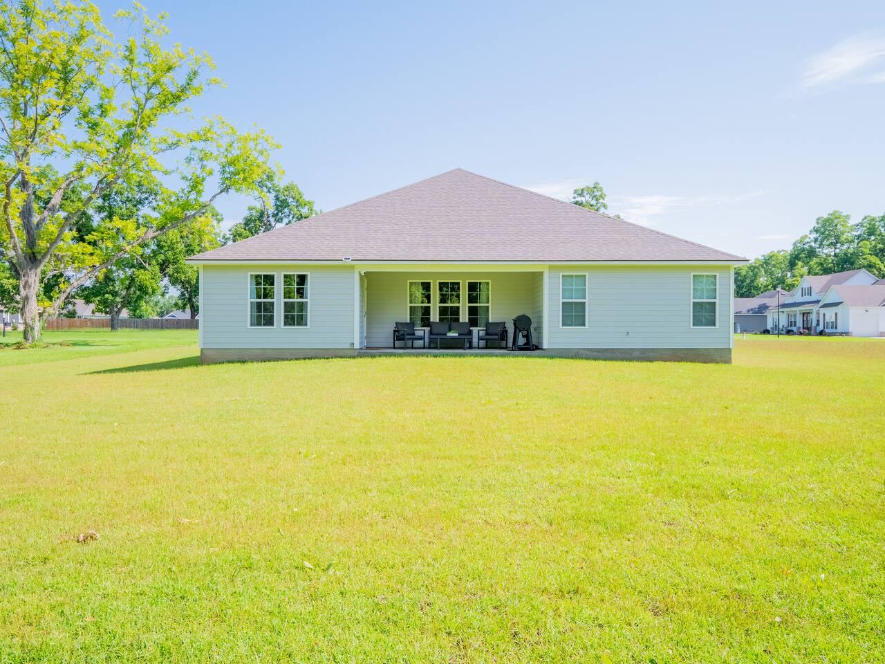Rear of the home and the open backyard lawn