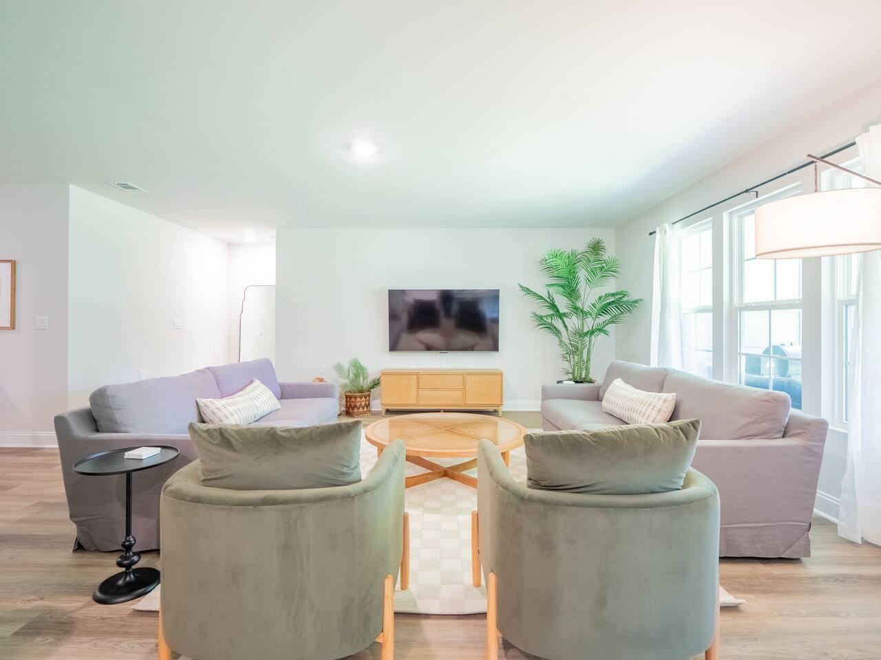 Living room with two sofas, armchairs and a wall-mounted smart TV